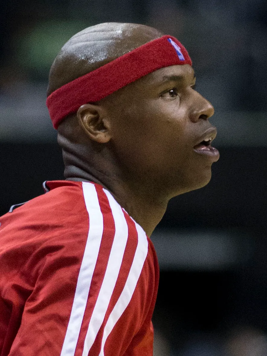 Al Harrington on court in a red headband and jersey.