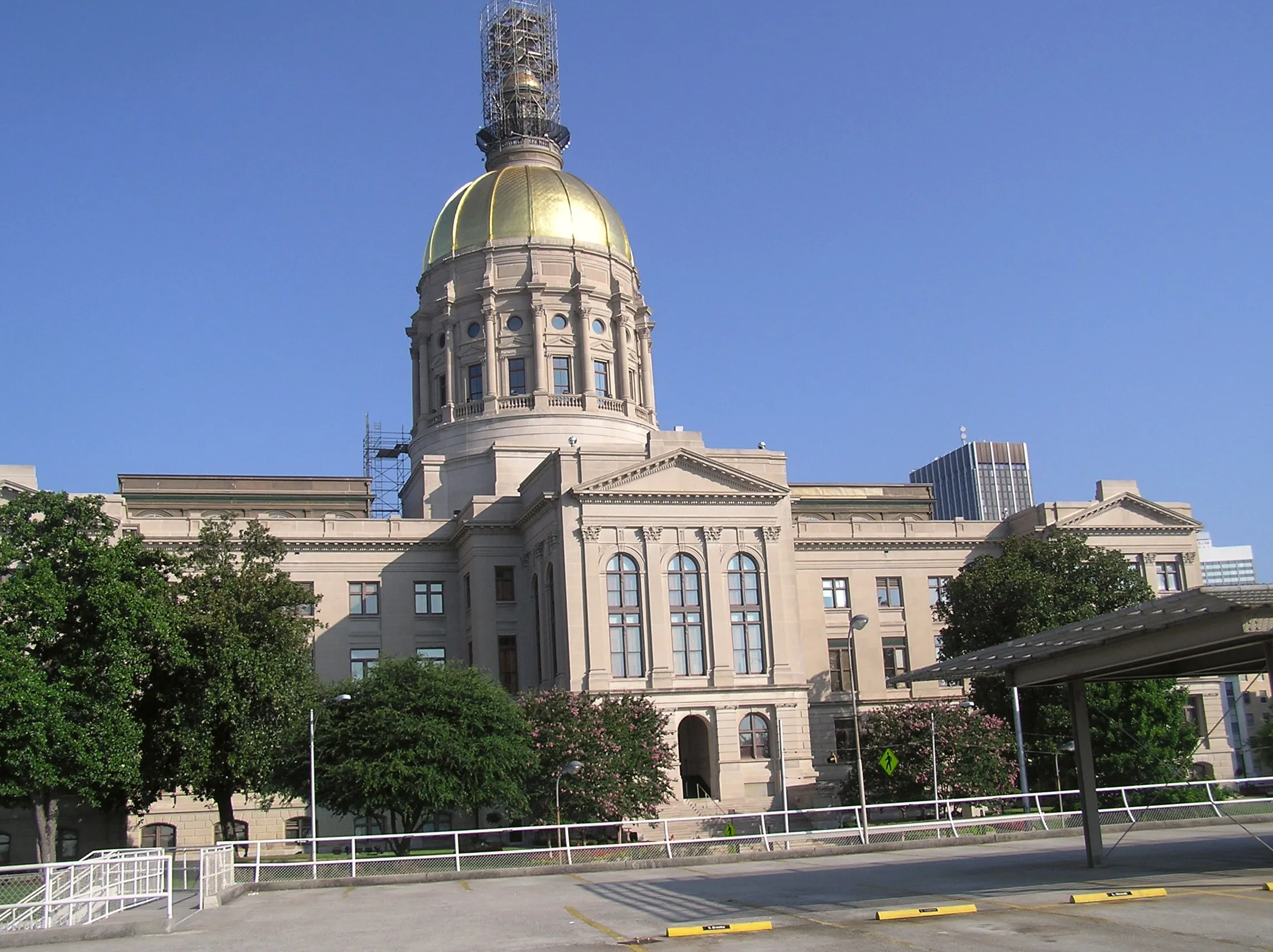 The Georgia State Capitol building in Atlanta, with its gold dome, under a blue sky.