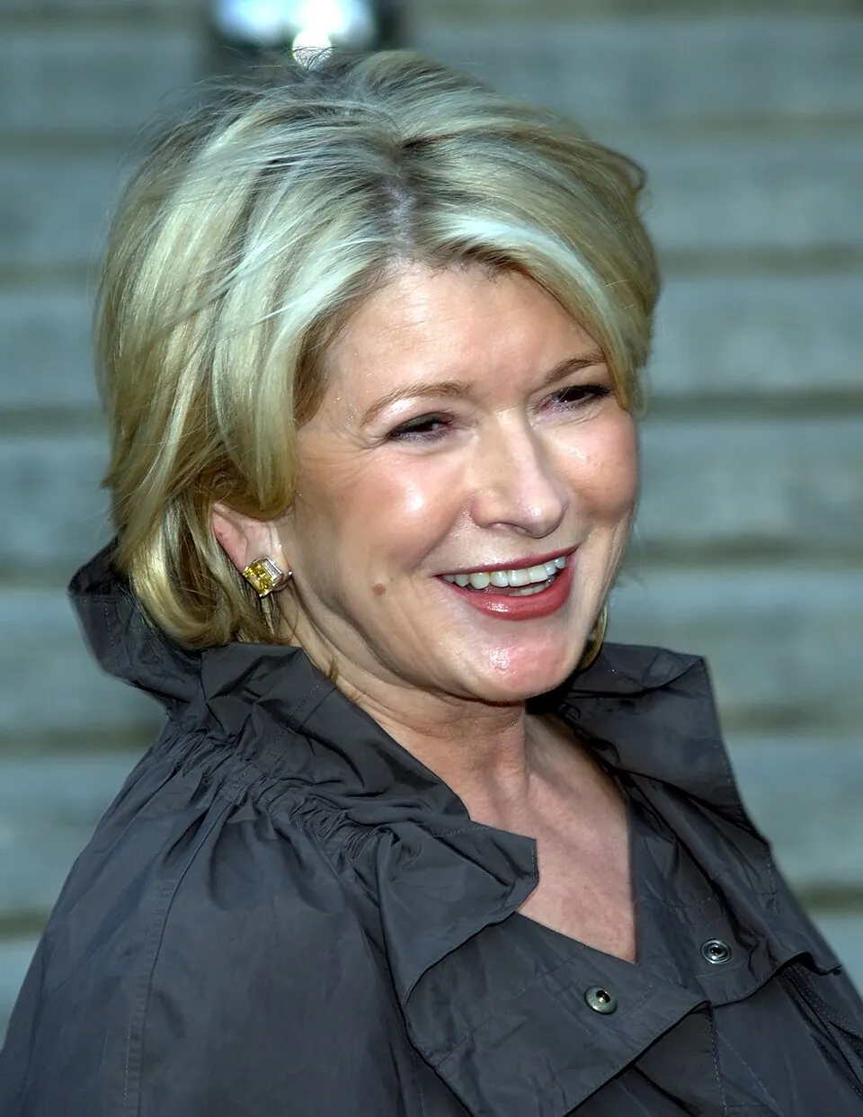 Martha Stewart smiling at an event in a dark coat.