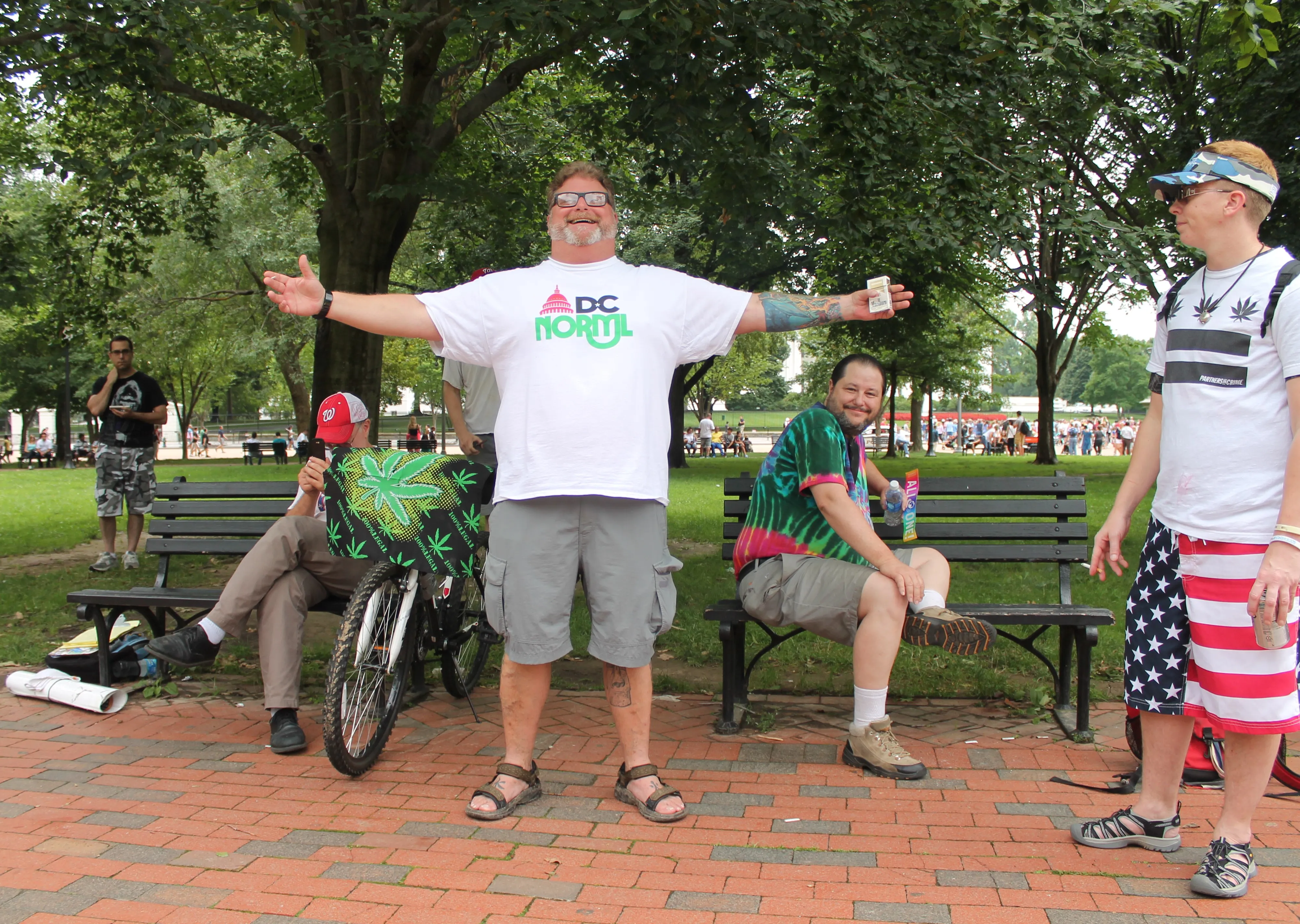 A cannabis-reform protest in a Washington, D.C. park, with people gathered under banners.